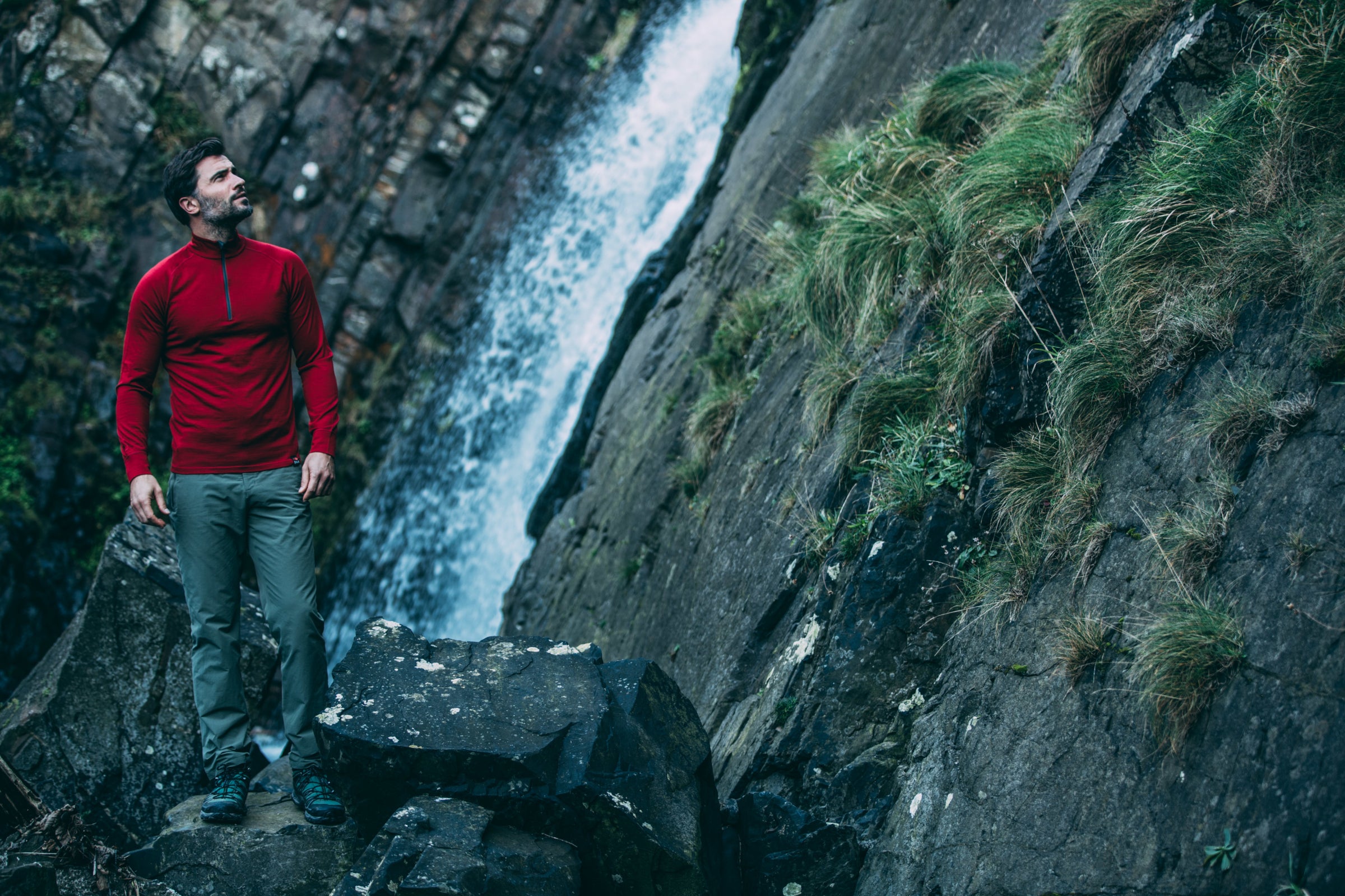 Man wearing Isobaa merino standing by a waterfall