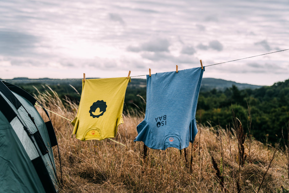 Isobaa Emblem Tee hanging on a clothes line next to a tent